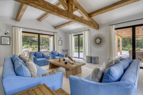 un salon avec des canapés bleus et une table dans l'établissement Luxurious Villa facing the Baie des Canebiers, à Saint-Tropez
