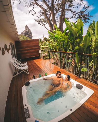 two men in a jacuzzi tub on a deck at Dolphin Hotel in Fernando de Noronha