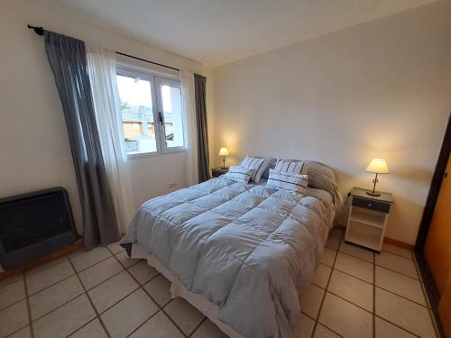 a bedroom with a large bed and a window at Ventanas de la Patagonia 2 in Esquel