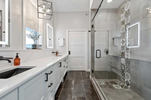 ein weißes Bad mit einer Dusche und einem Waschbecken in der Unterkunft Luxury Lakefront Condo with Private Hot Tub and Sauna in Watertown