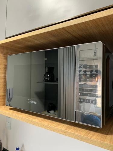 a microwave oven on a shelf in a kitchen at Pérola do Bessa in João Pessoa