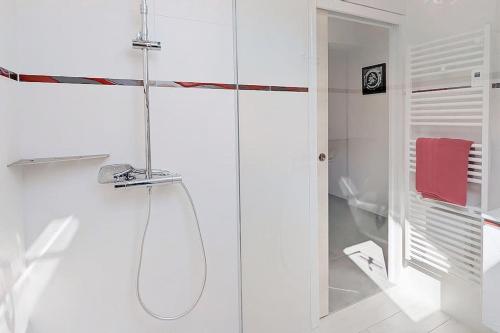 une salle de bain blanche avec une douche et un lavabo dans l'établissement Appartement pour 3 personnes Sur la plage Les pieds dans leau, à Plonévez-Porzay