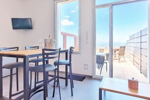une salle à manger avec une table et une vue sur l'océan dans l'établissement Appartement pour 3 personnes Sur la plage Les pieds dans leau, à Plonévez-Porzay