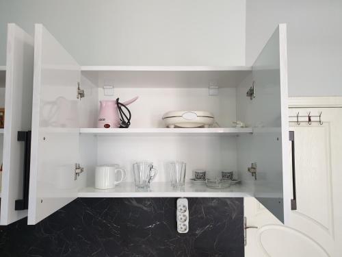 una cocina blanca con una estantería con utensilios. en Seven Suite Taksim en Estambul