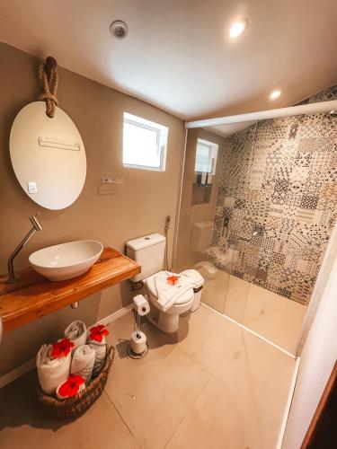 a bathroom with a toilet and a sink and a shower at Dolphin Hotel in Fernando de Noronha