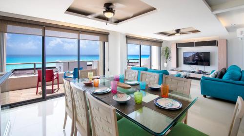 a living room with a dining table with a view of the ocean at Family Vacations apartment Ocean View in Cancún
