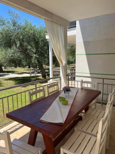 a wooden table and chairs on a balcony at Aria Prive in Himare