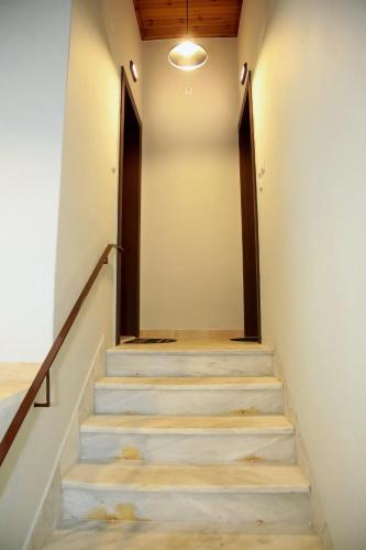 una escalera en una casa con barandillas de madera en Ante Portum, en Nafpaktos