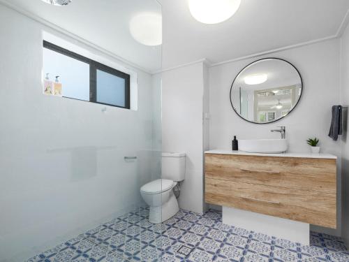 ein Badezimmer mit einem WC, einem Waschbecken und einem Spiegel in der Unterkunft Shoreline 3 Beachfront Apartment in Hastings Point