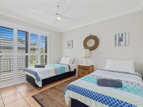 1 Schlafzimmer mit 2 Betten und einem Fenster in der Unterkunft Shoreline 3 Beachfront Apartment in Hastings Point