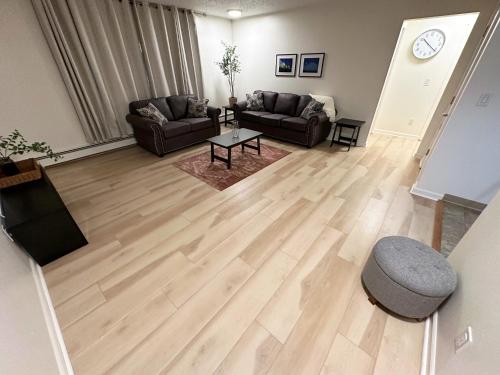 a living room with a wooden floor and couches at Stay Anchorage! Furnished Two Bedroom Apartments With High Speed WiFi in Anchorage