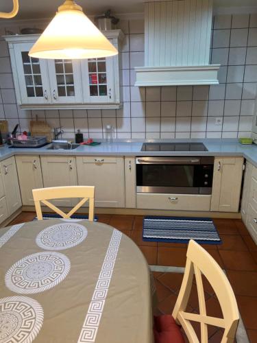 cocina con mesa, 2 sillas y fregadero en Casa Santiago, en Argoños