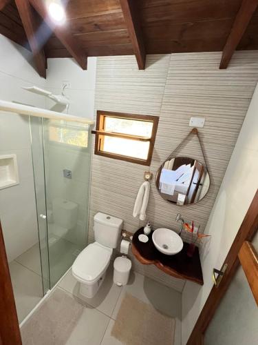 a bathroom with a toilet and a sink and a mirror at Casa para temporada em Paraty RJ - Sítio Primavera in Paraty