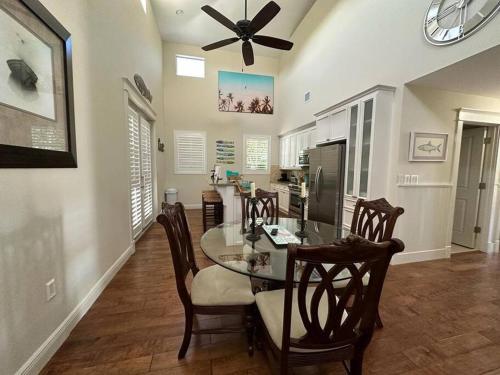 a dining room with a glass table and chairs at Mojito Breeze Getaway sleeps 11 and 2 full bathroom islamorada tavanier dock in Tavernier