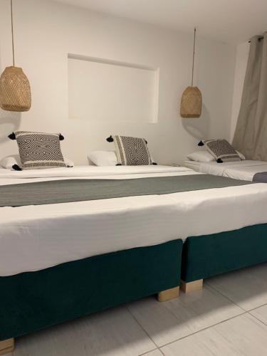 two large beds in a room with two at Hotel Quintas de Normandia in Bogotá