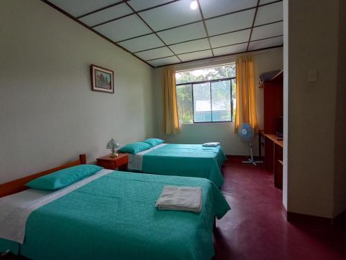 a room with two beds and a window at BUNGALOWS EL RANCHO in San Ramón