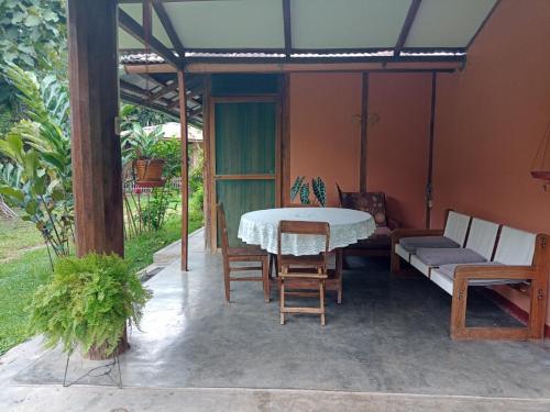 un patio con mesa, sillas y sofá en BUNGALOWS EL RANCHO en San Ramón