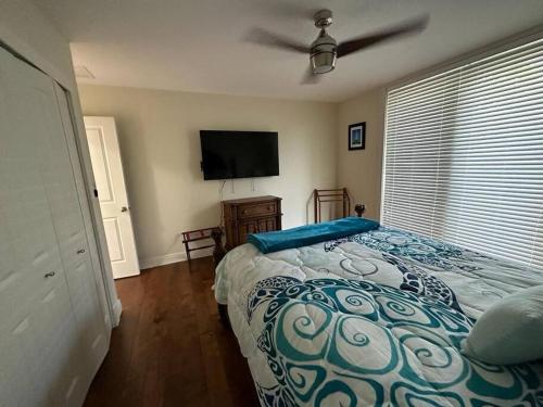 a bedroom with a bed and a flat screen tv at Mojito Breeze Getaway sleeps 11 and 2 full bathroom islamorada tavanier dock in Tavernier