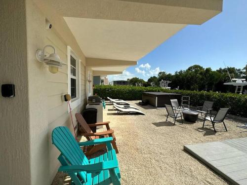 a patio with chairs and a table and a grill at Mojito Breeze Getaway sleeps 11 and 2 full bathroom islamorada tavanier dock in Tavernier