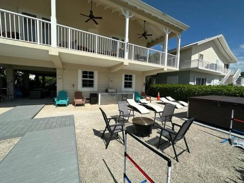a patio with chairs and a grill in front of a house at Mojito Breeze Getaway sleeps 11 and 2 full bathroom islamorada tavanier dock in Tavernier