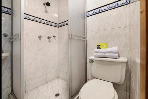 a bathroom with a toilet and a shower at Hotel Quintas de Normandia in Bogotá