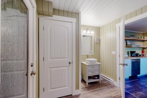 baño con lavabo y puerta blanca en Mill Pond Suite, en East Boothbay