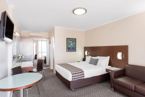 a hotel room with a bed and a couch and a table at BreakFree Queanbeyan in Queanbeyan