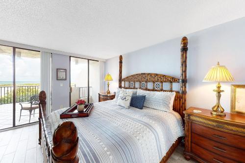 a bedroom with a large bed and a balcony at Lighthouse Towers #206 in Clearwater Beach