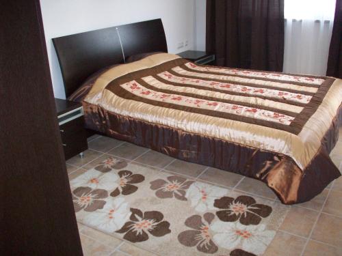een slaapkamer met een groot bed en een bloemkleed bij Apartments Helios in Pomorie