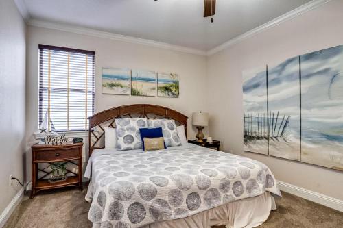 een slaapkamer met een bed en schilderijen aan de muur bij Waterdog II in Destin