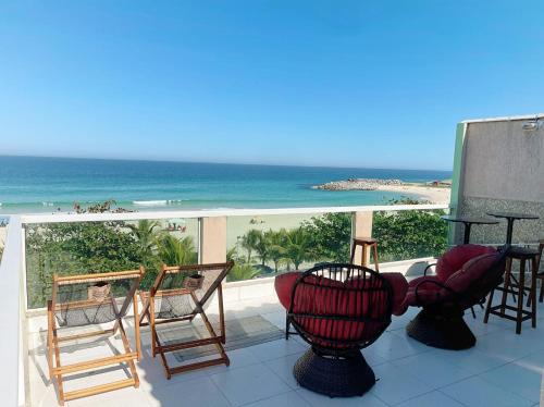 a balcony with chairs and a view of the beach at Felicidade in sea front in Saquarema