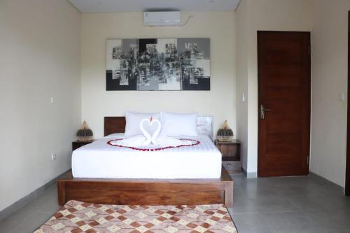 Un dormitorio con una gran cama blanca y una puerta en Regama Ubud villa en Ubud