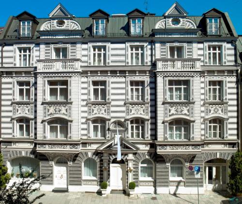 un antiguo edificio con una bandera delante de él en Hotel Opera, en Múnich