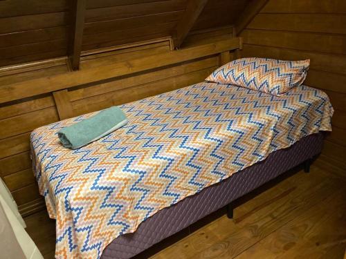 Łóżko w pokoju z drewnianą podłogą w obiekcie Pousada Chalé Flor de Hibisco 3 w mieście Penha
