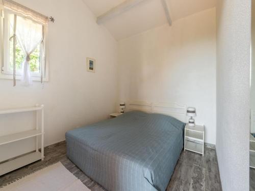 a white bedroom with a bed and a window at Apartment near Saint Tropez Beach in Roquebrune-sur-Argens