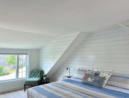 a bedroom with a bed and a green chair at Kingfisher Harwich Port in Harwich Port