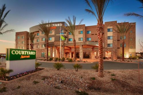 d'un hôtel avec un panneau et des palmiers dans l'établissement Courtyard by Marriott Phoenix Mesa Gateway Airport, à Mesa