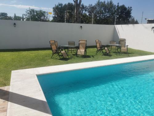 una piscina con sillas y una mesa junto a una valla en Alquiler de Hermosa Casa sola con Piscina Privada, en Los Limones