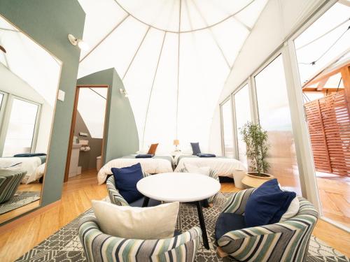 a room with a table and chairs and windows at GLAMP ELEMENT(グランエレメント） in Maibara