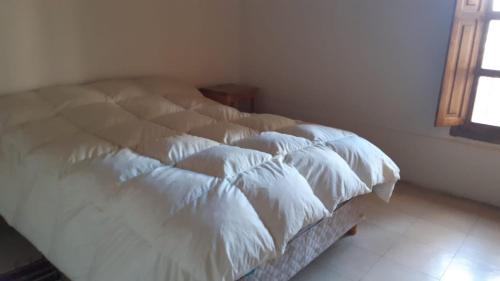 - un lit blanc avec quatre oreillers dans une chambre dans l'établissement Punta del Barro, à Iglesia