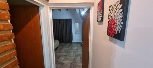 um corredor que leva a um quarto com uma parede de tijolos em Complejo Boulevard Plottier em Plottier