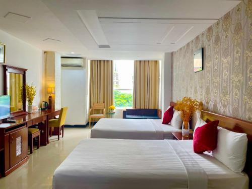 um quarto de hotel com duas camas e uma televisão em Gold hotel, Saigon em Cidade de Ho Chi Minh