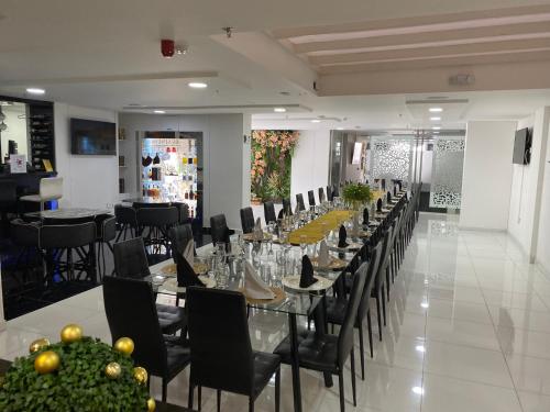 uma sala de jantar com mesas longas e cadeiras em Hotel Business Center em Popayán