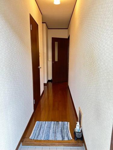 a hallway with a door and a rug on the floor at KASUMI-an Sora in Shimo-tatsuda
