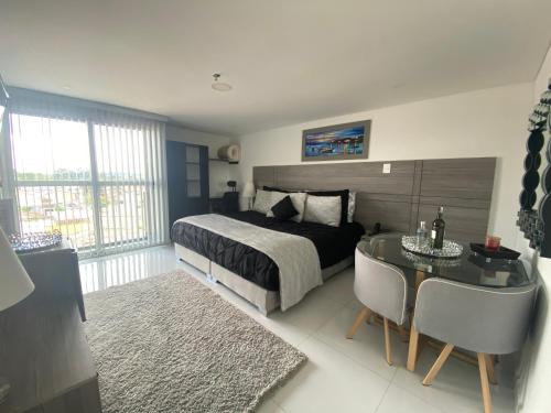um quarto com uma cama, uma secretária, uma mesa e cadeiras em Hotel Business Center em Popayán