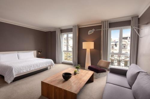 une chambre d'hôtel avec un lit et un canapé dans l'établissement Le Meridien Barcelona, à Barcelone