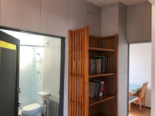 a bathroom with a book shelf next to a toilet at Bema 3 Darłowo in Darłowo