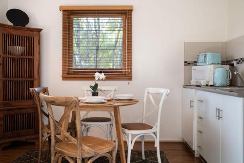 a small kitchen with a wooden table and chairs at Gables Bend On High in Daylesford