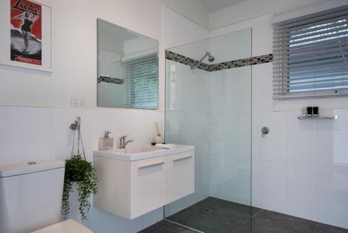 a white bathroom with a sink and a mirror at Gables Bend Spa Villa in Daylesford