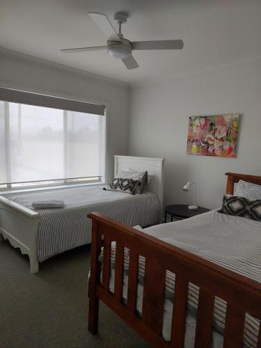 a bedroom with two beds and a ceiling fan at COD & C0 Tocumwal in Tocumwal